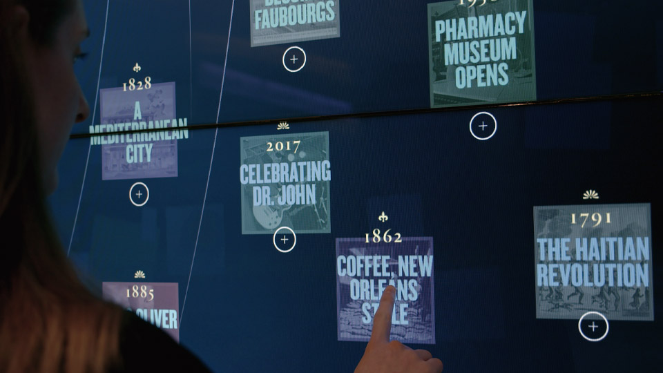 Visitor reaching toward year tiles on the interactive media wall, spanning 1791 to 2017