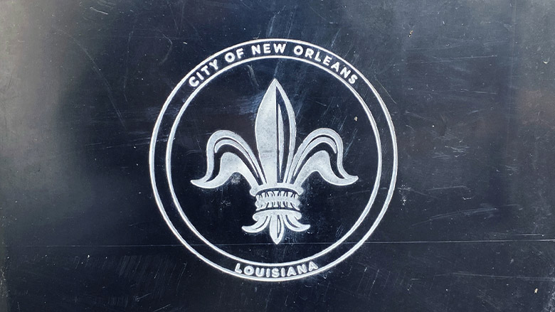 City of New Orleans fleur-de-lis seal on a weathered dark ground