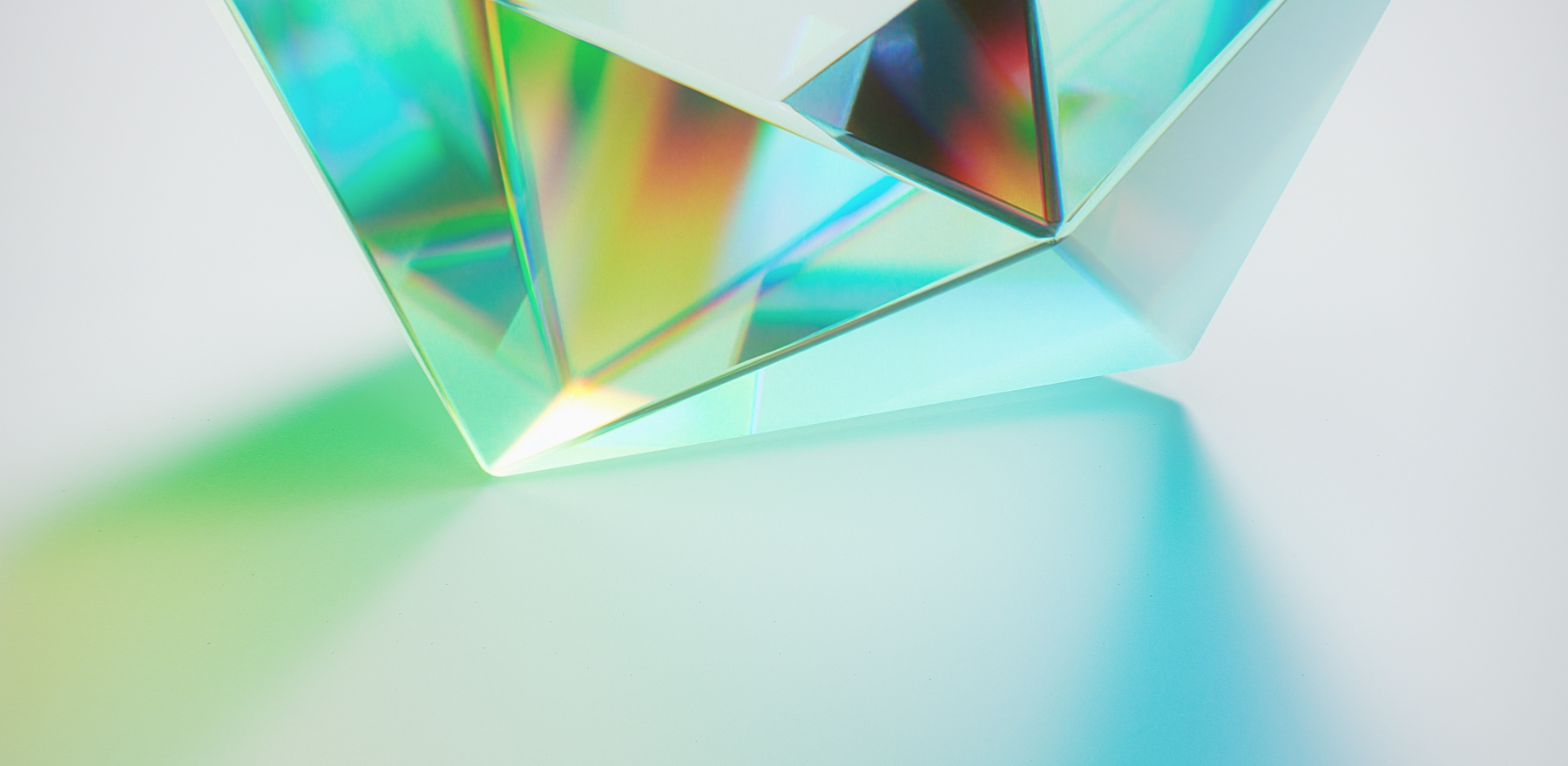 Glass prism refracting light into a spectrum across a pale surface